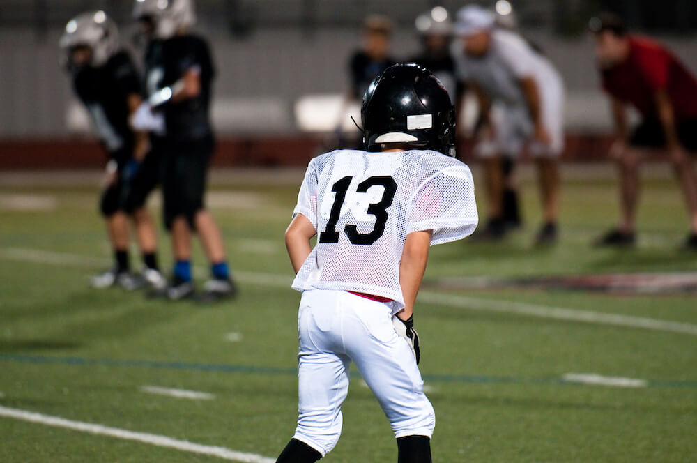 Child in football uniform on field